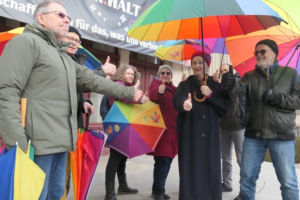 Teilnehmende mit bunten Regenschirmen